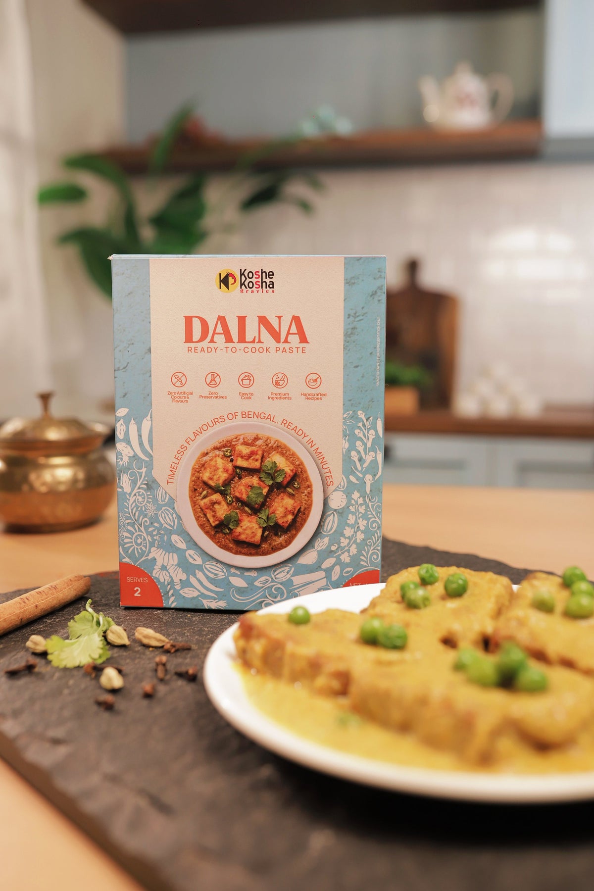 Dalna box with a plate of chhanar dalna, cinnamon and cardamom in a home kitchen