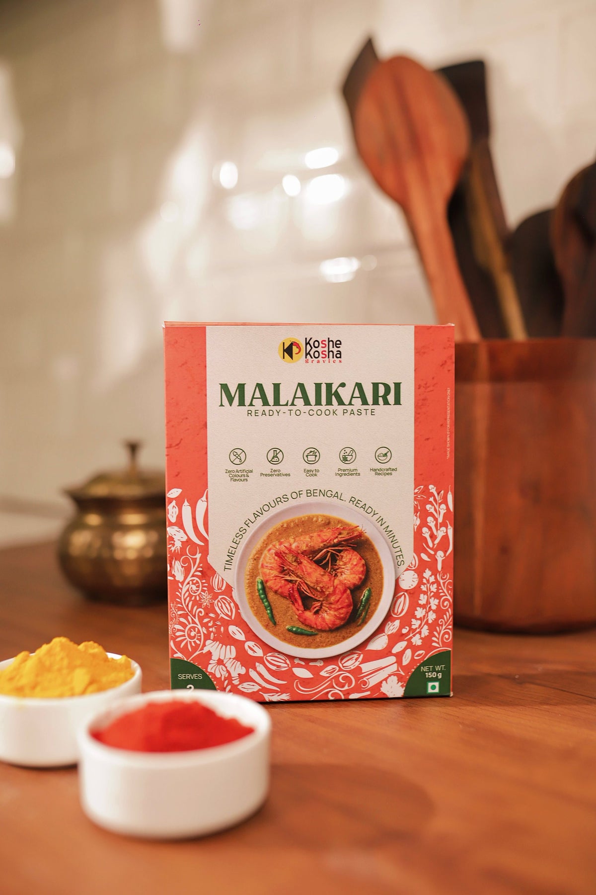 Malaikari box on a wooden counter with bowls of turmeric and red chilli powder